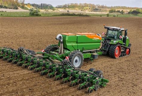 Nuotrauka, vaizduojanti kombainą, kulti sėjamųjų sojų lauką