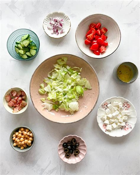 Kelių rūšių salotų ingredientai ir paruoštos salotos su avinžirniais