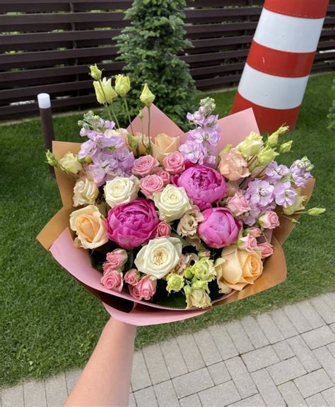 Erdvus gėlynas su įvairių spalvų bijūnais