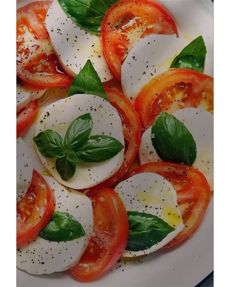 Artimas vaizdas į supjaustytą mocarelą ir pomidorus, paruoštus Kaprio salotoms